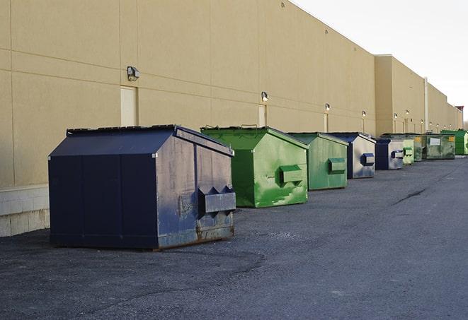 construction workers toss wood scraps into a dumpster in Eddyville